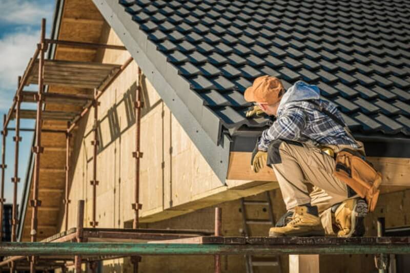 Man checking the roof of a house